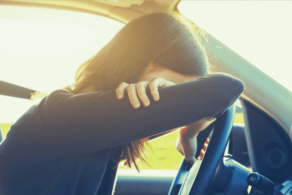 A woman who may be too drunk to drive crying in her vehicle-DUI Lawyers Tucson