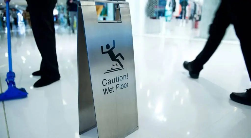 Caution sign indicating wet floor, highlighting slip and fall hazards in a public space, relevant to personal injury law and safety awareness.