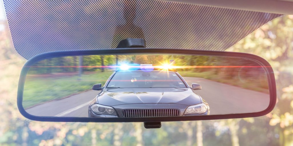 A police car in the rear view mirror, which could result in a failure to stop charge if the person doesn't pull over
