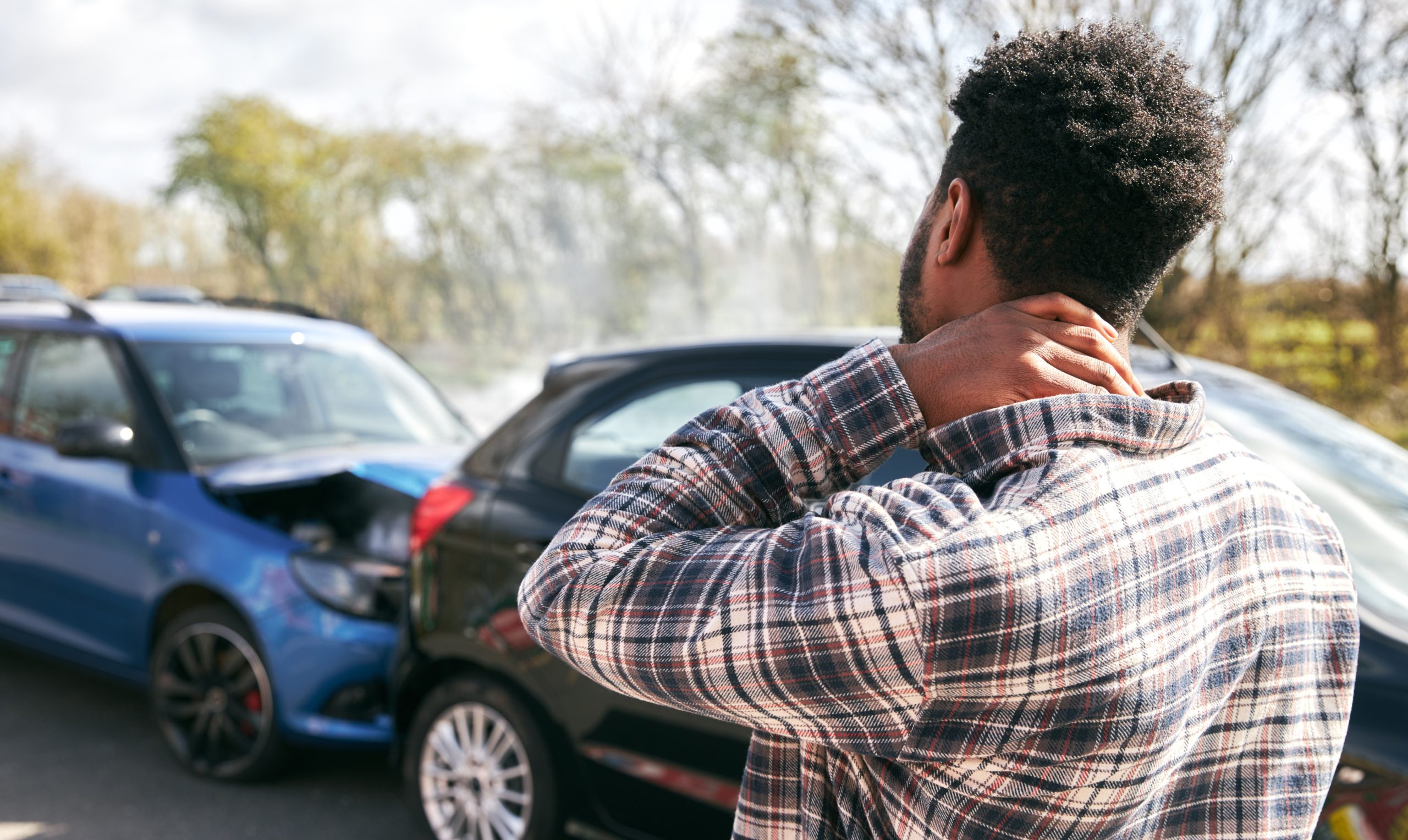 a man holding his neck after a car accident