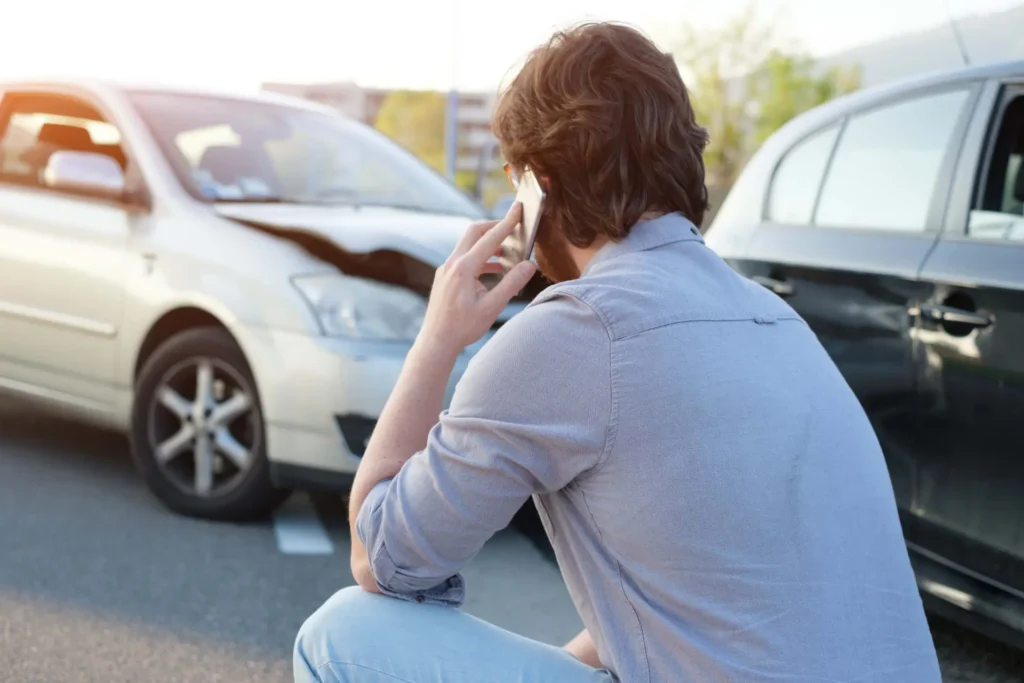 a man calling a car crash lawyer after a car crash accident on the road