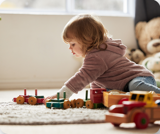 Child playing with wooden toy train illustrating defective product injuries in Tucson, Arizona.