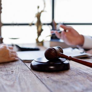 Two lawyers Consultation and conference discussing legal matters at a desk with a gavel, scales of justice law symbolizing law and justice, justice and lawyer Business partnership meeting concept.