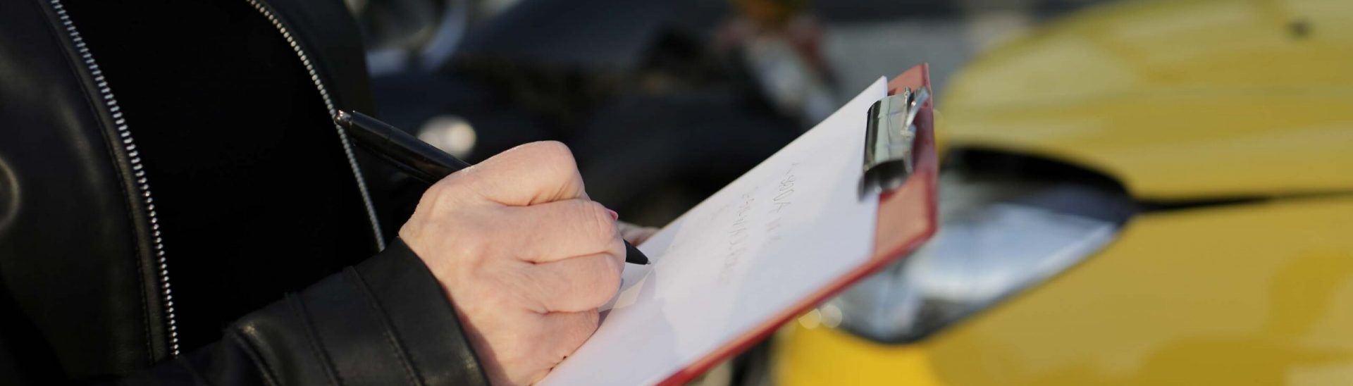 A woman recording a car accident between a black and a yellow car