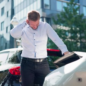 Young Man Suffering From Neck Pain After Car Accident. Seeking Legal Aid For Compensation For Auto Injury Whiplash.